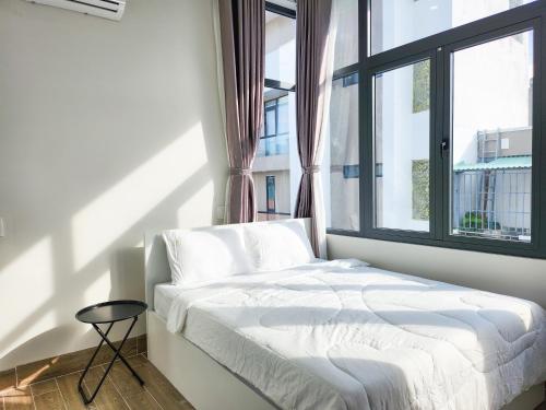 a bed in a room with a large window at An Home - Phòng đơn ngay bãi sau Vũng Tàu in Vung Tau