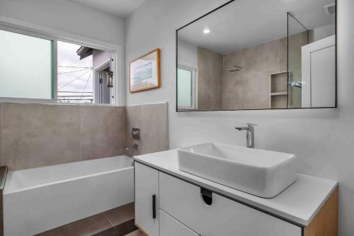 a bathroom with a sink and a tub and a mirror at Meridian Manor in Alhambra