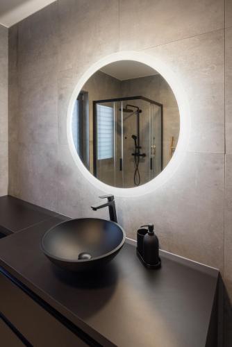a bathroom with a black sink and a mirror at Apartmány Na Lánech in Litomyšl