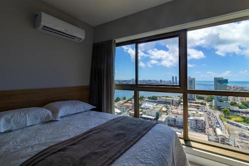 a bedroom with a bed and a large window at Parque Shopping #2001 - Apartamento Aconchegante em Boa Viagem por Carpediem in Recife