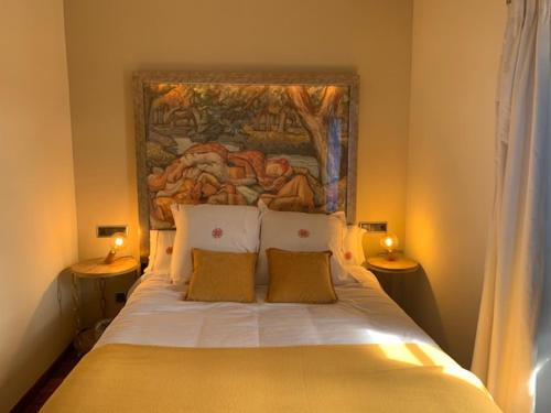 1 dormitorio con 1 cama con una pintura en la pared en CASA DO ARXENTINO, en Mera