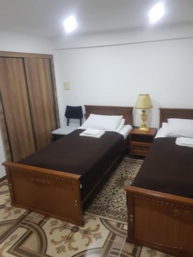 a hotel room with two beds and a chair at тихий дворик in Baku