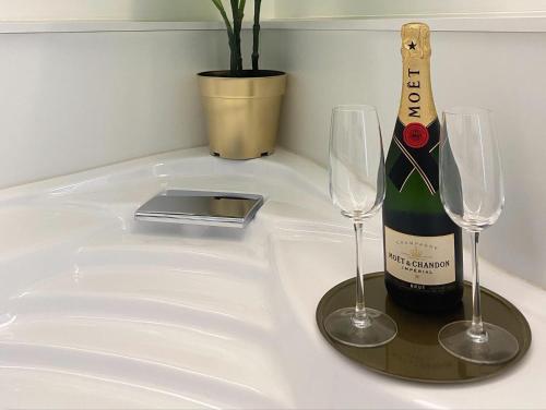 a bottle of champagne and two wine glasses on a counter at GUALTIERI LUXURY SUITE in San Giorgio a Cremano