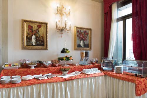 a table with plates and dishes on it in a room at Hotel Villa Stucky in Mogliano Veneto