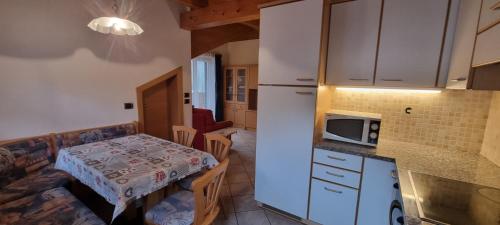 a small kitchen with a table and a microwave at Casa Soraruf in Campitello di Fassa