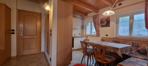 een keuken en eetkamer met een tafel en stoelen bij Casa Soraruf in Campitello di Fassa