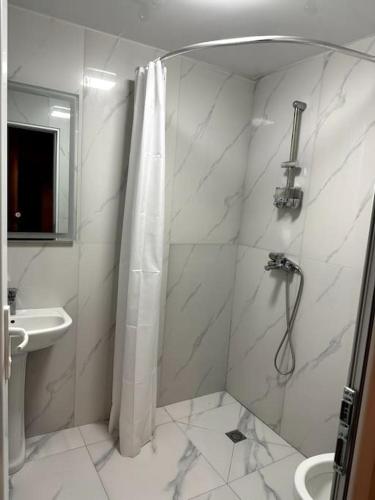 uma casa de banho branca com um chuveiro e um lavatório. em BEST VIEW OF KUTAISI em Kutaisi