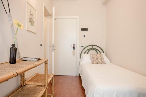 a small bedroom with a bed and a table at Villa Arizona in Milano Marittima