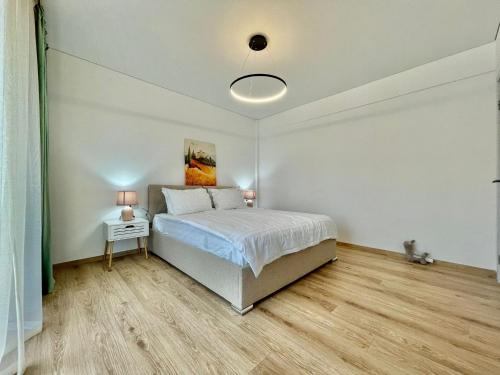 a bedroom with a bed and a table with two lamps at Residence Odaile #1 in Otopeni