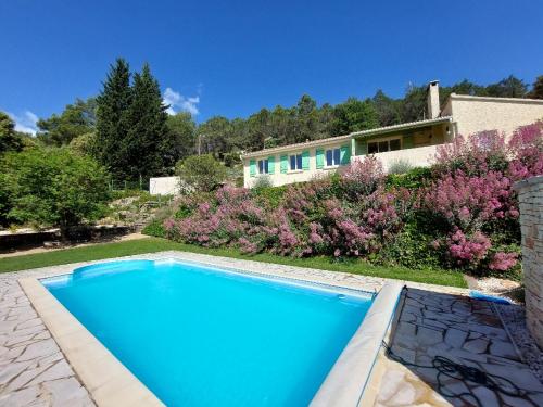 une piscine bleue devant une maison dans l'établissement Villa spacieuse à Saint-Nazaire avec piscine privée, à Saint-Nazaire