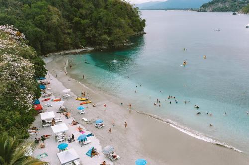 an aerial view of a beach with people in the water at Parador Nature Resort and Spa in Manuel Antonio