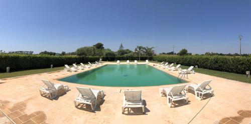 un grupo de sillas y una piscina con un montón de plantas en Torre Santo Stefano en Otranto