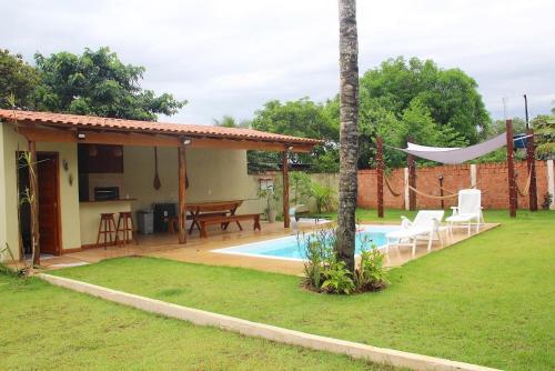 un patio trasero con piscina y una casa en Chalé Ubá en Novo Airão