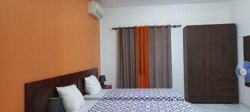 a bedroom with a bed and an orange curtain at Ka-Bela 2 in Sal Rei