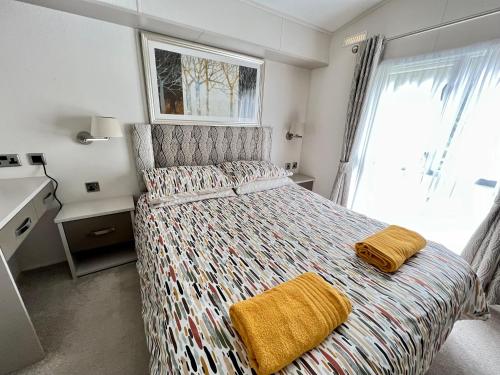 a bedroom with a bed with two towels on it at Waterside Lodge in South Cerney