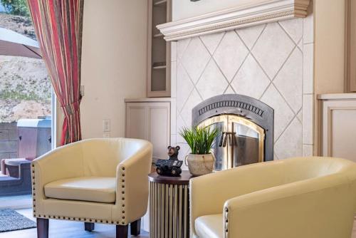 a living room with two chairs and a fireplace at Manic Mountain Forest Cabin 3 miles from Bass Lake in Oakhurst