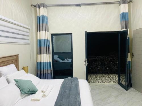 1 dormitorio con 1 cama y una gran puerta corredera de cristal en modern, two-story luxury house, en Gaborone