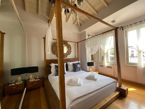 1 dormitorio con cama con dosel en una habitación en Nisi Hotel, en Ayvalık