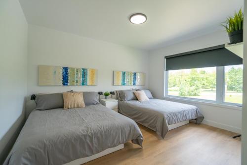 a bedroom with two beds and a window at Halte 4 Saisons- en nature à 5 min du Mont-Orford! in Orford