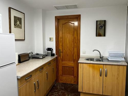 - une cuisine avec un évier et une porte en bois dans l'établissement GRACIA, à Cordoue