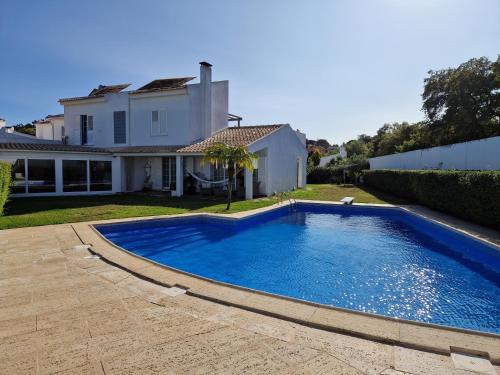 a swimming pool in the yard of a house at Villa Armanbel in Sesimbra