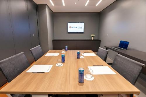 a conference room with a large wooden table and chairs at Intercity Tatuapé in Sao Paulo