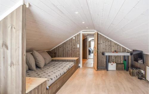 a bed in a room with wooden walls at Amazing Home In Sjusjen With 4 Bedrooms, Sauna And Wifi in Sjusjøen
