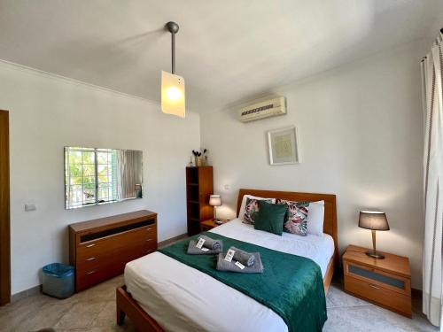 um quarto com uma cama com lençóis verdes e brancos em Tavira Palm Tree by Homing em Tavira