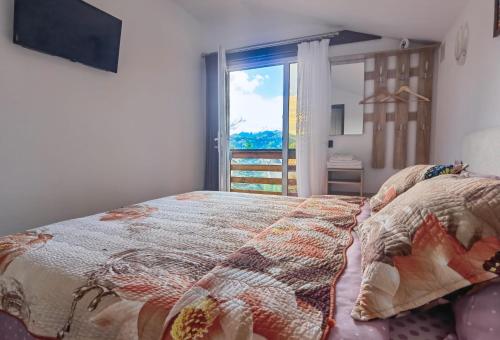 a bedroom with a bed and a large window at Casa Danci II in Borşa