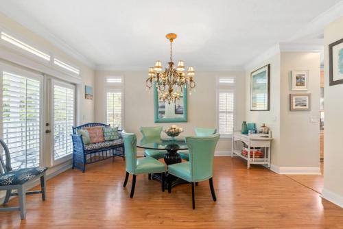 a dining room with a table and chairs and a chandelier at Casa Aqua in Saint Augustine