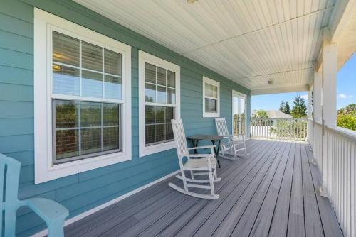 a blue house with two chairs and a table on a porch at Casa Aqua in Saint Augustine