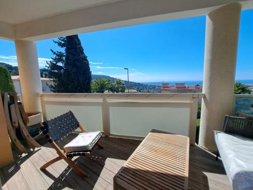 einen Balkon mit einem Stuhl und einer Bank auf einer Terrasse in der Unterkunft Luxurious sea view apartment Cannes Vieux Cannet in Le Cannet