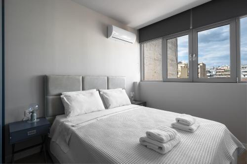 a bedroom with a bed with two towels on it at #Luxlikehome Lux Locals 1 in Thessaloniki