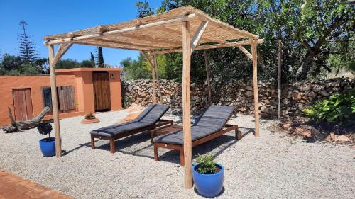 uma pérgola de madeira com 2 cadeiras num pátio em Rural Peace in the Algarve - Private Room with kitchenette and bathroom em Aldeia dos Matos
