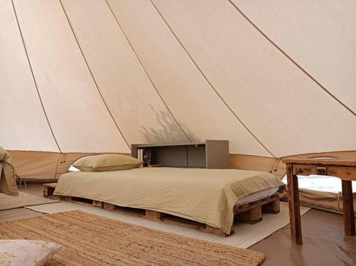 een slaapkamer met een bed in een tent bij Meltheane in Lygia
