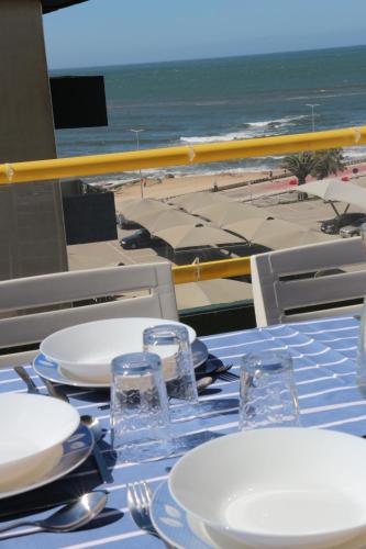 a table with plates and glasses and a view of the beach at FFoz_Spot in Buarcos
