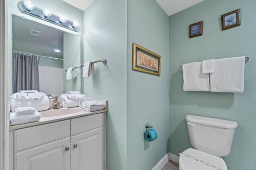 a bathroom with a sink and a toilet and a mirror at Shores of Panama #2302 by Nautical Properties in Panama City Beach