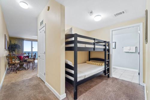a bedroom with bunk beds and a dining room at Shores of Panama #2302 by Nautical Properties in Panama City Beach