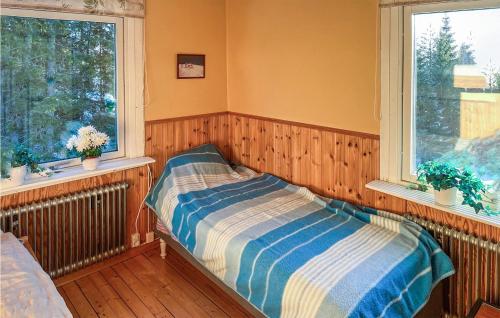 a bedroom with a bed and two windows at Amazing Home In Frnsta With Sauna, Wifi And 3 Bedrooms in Fränsta