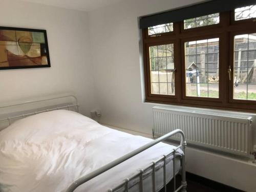 a white bed in a room with a window at The Barn in Trotterscliffe