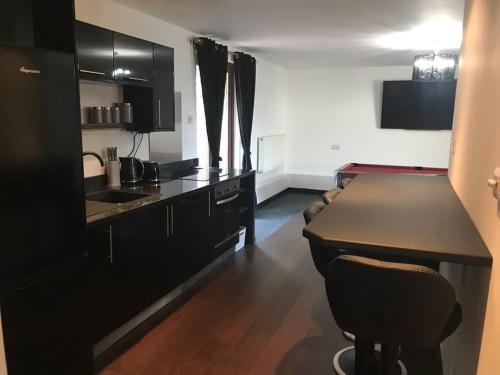 a kitchen with black cabinets and a counter top at The Barn in Trotterscliffe