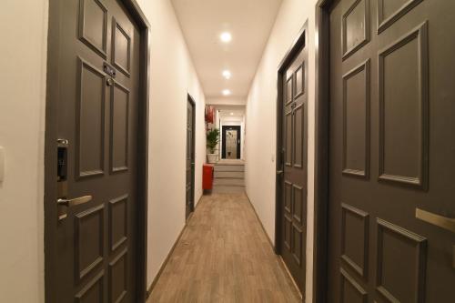 a hallway with black doors and wooden floors at Super Townhouse Royapettah Near U.S Consulate in Chennai