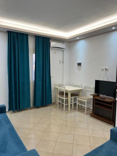 a living room with a table and a television at Hotel Arsenal in Ksamil