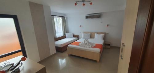 a bedroom with a bed and a couch and a chair at Pensiunea Casa Beatrice in 2 Mai