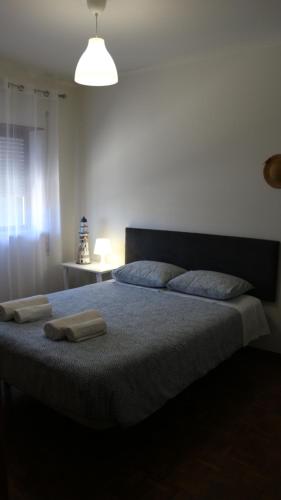 a bedroom with a large bed with two towels on it at FFoz_Spot in Buarcos