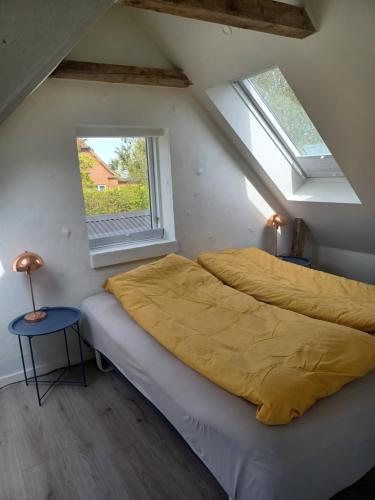 een slaapkamer met 2 bedden en een raam bij Tæbring Holiday Home in Nykøbing Mors