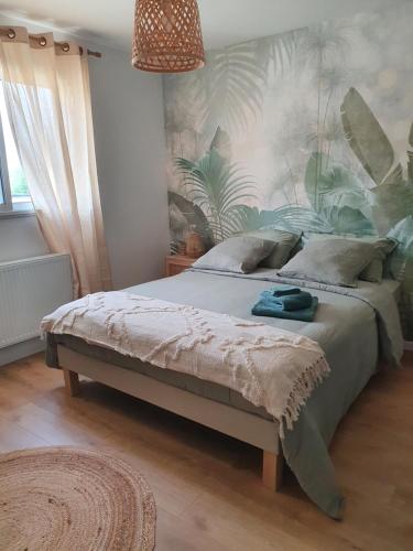 a bedroom with a large bed with a tropical wallpaper at Chambres près du circuit in Changé