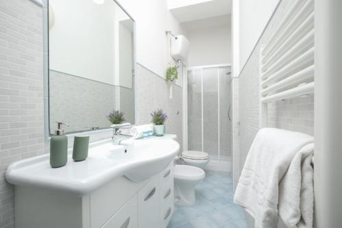 Un baño blanco con lavabo e inodoro. en Green Coast House 4, en Piombino