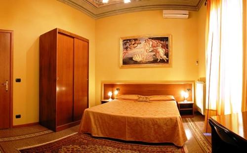 a bedroom with a bed and a painting on the wall at La Luna Guest House in Florence