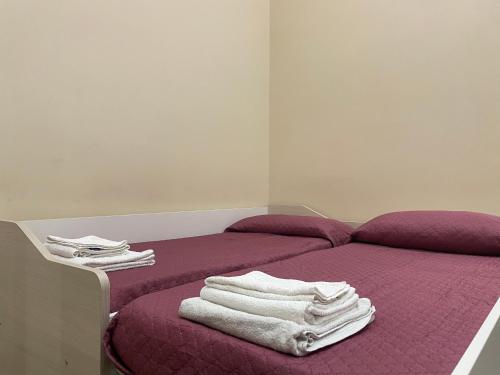 ein Bett mit weißen Handtüchern darüber in der Unterkunft Nonna Concetta B&B Nocera - Vicino Tribunale di Nocera - Ristrutturato 2022 in Nocera Inferiore